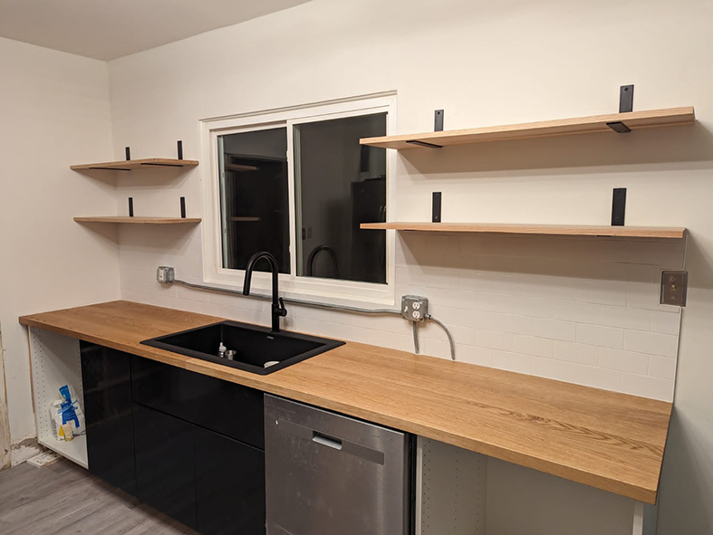 Open shelving with wood countertop and white backsplash