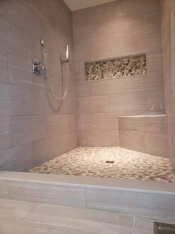 Master shower with tall curb, corner bench, and custom niche 12x36