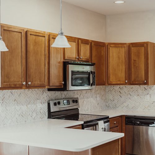 Herringbone backsplash with slim Shaker cabinets in Asheville kitchen remodel